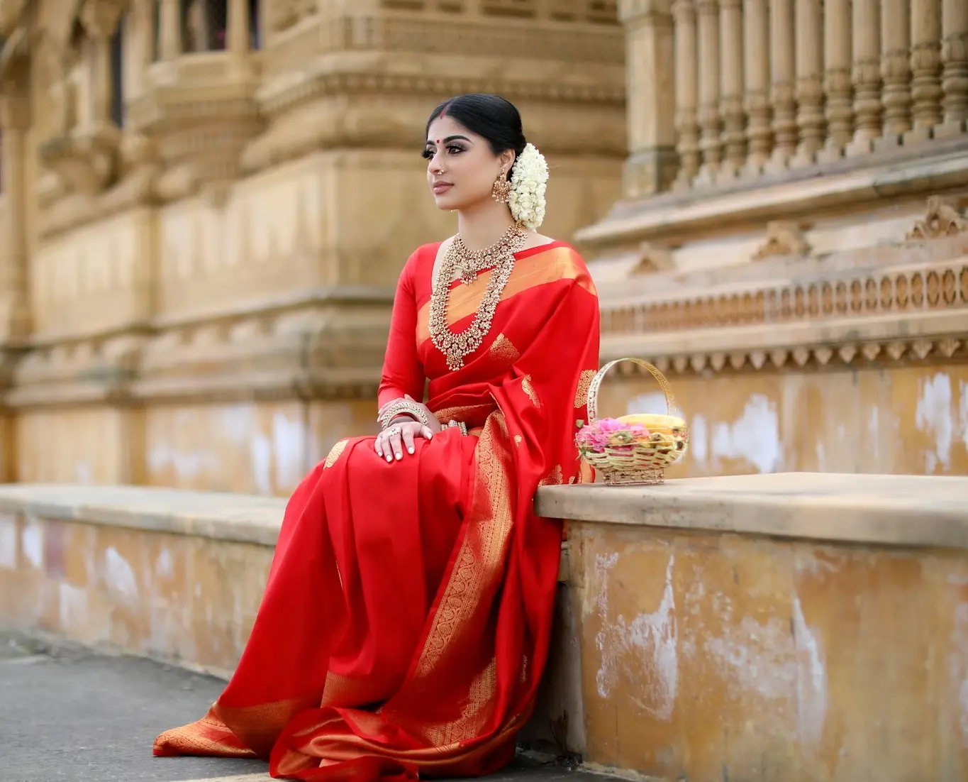 woman in red long sleeve dress sitting on gray concrete bench during daytime